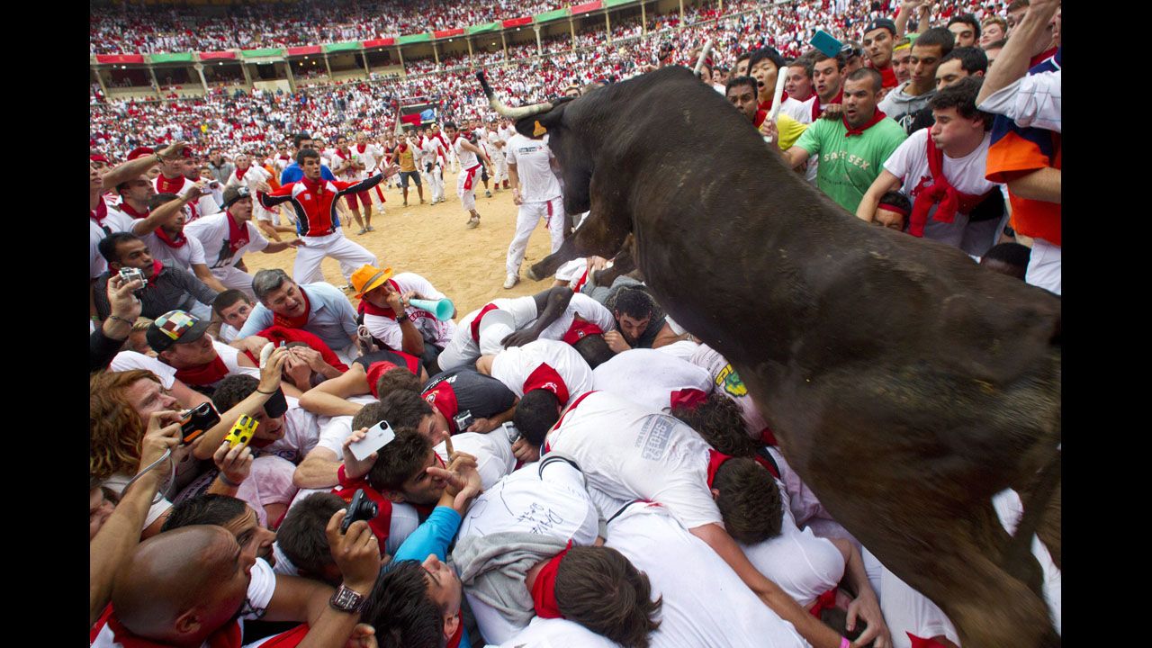 <strong>July 8:</strong> A wild bull hurdles over people blocking the animal's way into the bullring at the close of the second bull run during the Fiesta de San Fermin in Pamplona, Spain. The festival attracts thousands of people who attempt to outrun the bulls through the narrow streets of the old city.