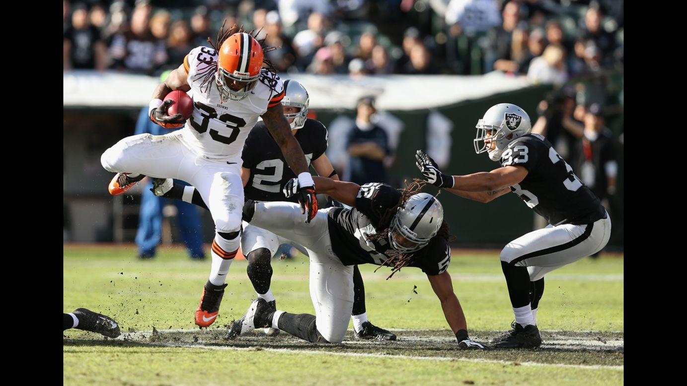 Trent Richardson of the Cleveland Browns jumps over Philip Wheeler of the Oakland Raiders on Sunday.