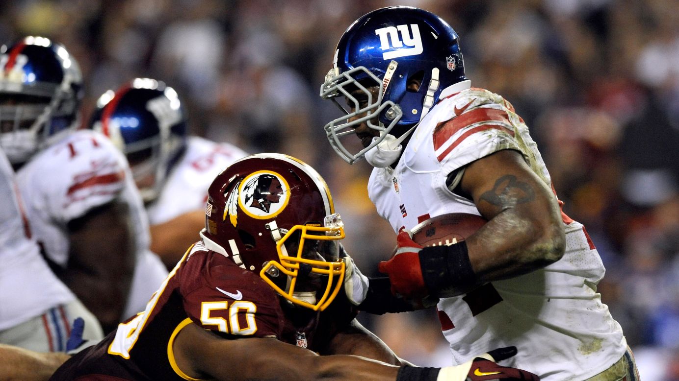 Ahmad Bradshaw of the New York Giants runs the ball Monday as he is hit by Rob Jackson of the Washington Redskins.