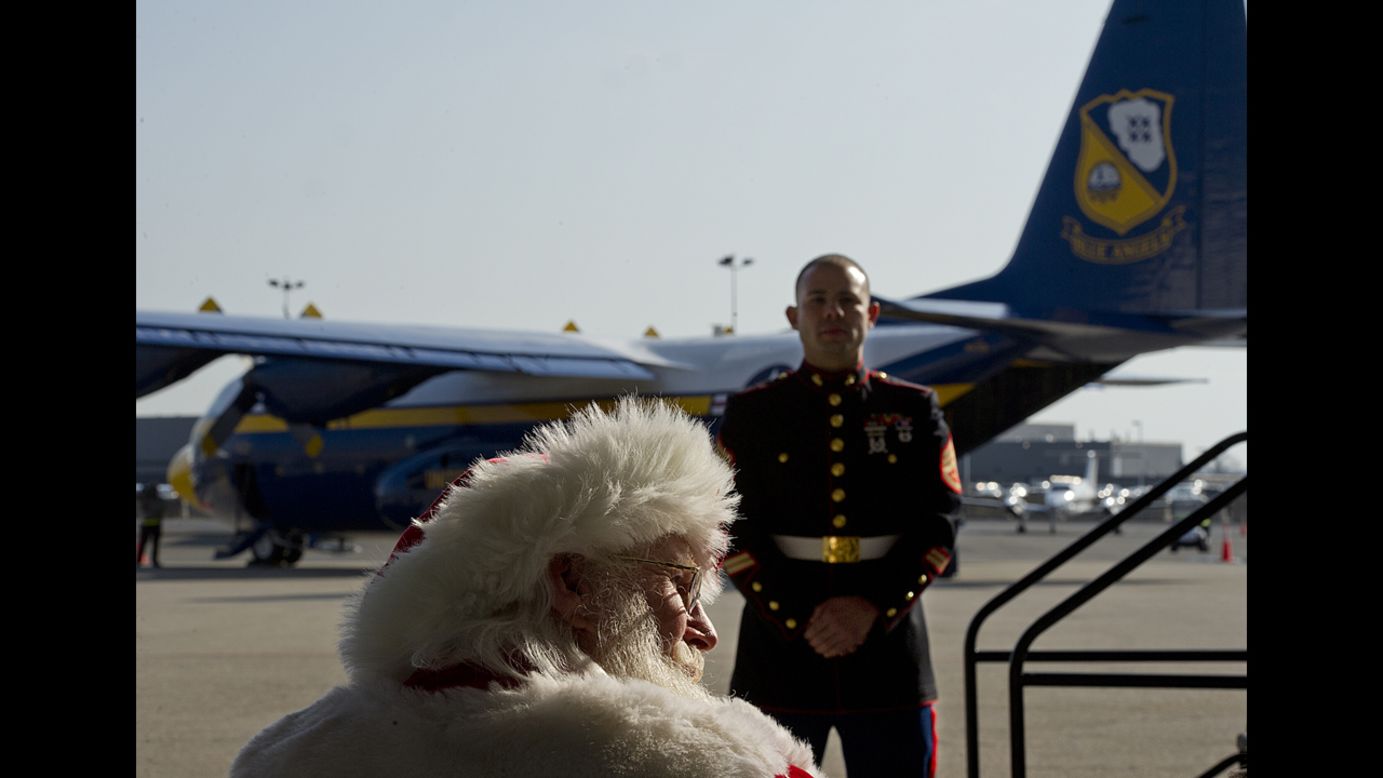 Santa Claus, aka Tim Connaghan, sits in the audience while a Marine stands guard during a presentation at Ronald Reagan National Airport on Monday, December 3, as part of the Marines' Toys for Tots program. Thousand of donated toys are set to be delivered to families affected by Hurricane Sandy. 