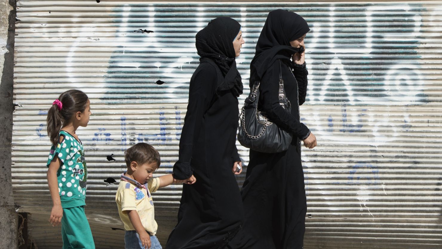 Syrian women walk past a closed shop in  Azaz. Violence against women is a big part of the war in Syria.

