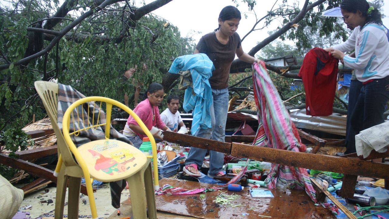 Residents gather their belongings after their house was destroyed by strong winds brought about by Typhoon Bophal earlier this month.