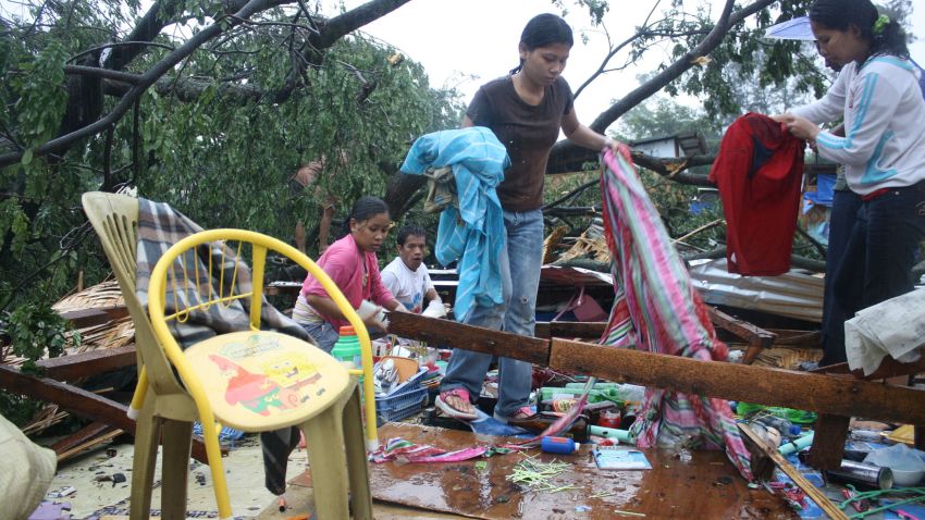 Residents gather their belongings after their house was destroyed by strong winds brought about by Typhoon Bophal in Cagayan de Oro City, southern island of Mindanao on December 4, 2012. Typhoon Bopha smashed into the southern Philippines early December 4, as more than 40,000 people crammed into shelters to escape the onslaught of the strongest cyclone to hit the country this year. AFP PHOTO (Photo credit should read STR/AFP/Getty Images) 