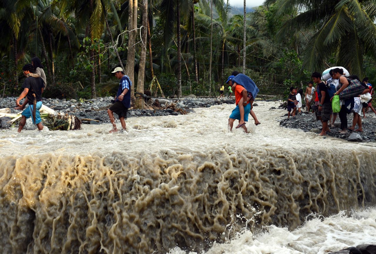 Residents cross a road destroyed at the height of Typhoon Bopha in the village of Andap, New Bataan township, Compostela Valley province on December 5.