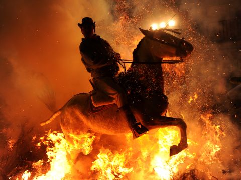 <strong>January 16:</strong> A man rides a horse through a bonfire in the small village of San Bartolome de Pinares, Spain, in honor of San Anton, the patron saint of animals.