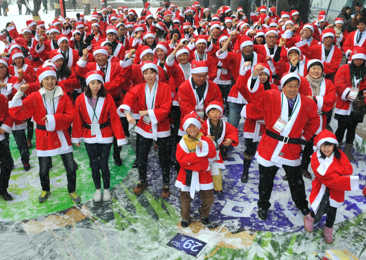 People in Santa Claus outfits imitate South Korean rapper Psy's famous "Gangnam Style" dance outside offices in Seoul, South Korea, on Wednesday, December 5. The dance marked the start of a charity mission to hand out gifts to children.