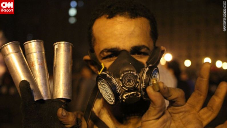 An anonymous protester holds empty tear gas canisters and a shell casing in this photo by <a href="http://ireport.cnn.com/docs/DOC-885571">iReporter Hasan Amin</a> at a demonstration that turned violent on November 24. Protests began shortly after Morsy announced his powers extension on November 22.