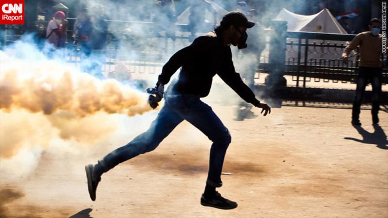 In this image by iReporter Hasan Amin, taken on November 27, a protester is captured preparing to throw back a tear gas canister fired by police.