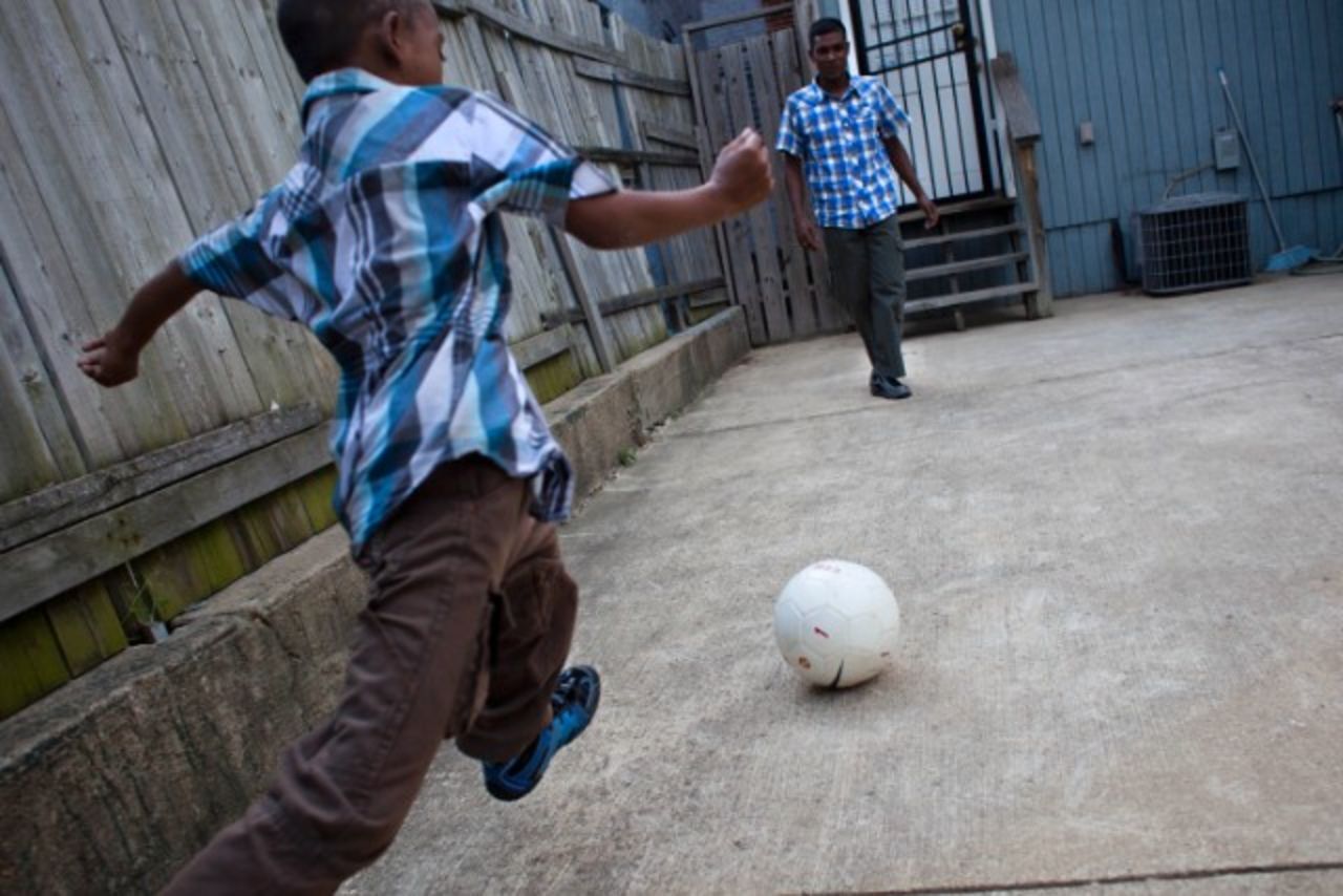 A Bangladeshi boy plays soccer with his father in Baltimore, Maryland.