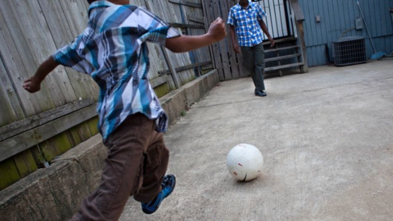 A Bangladeshi boy plays soccer with his father in Baltimore, Maryland.
