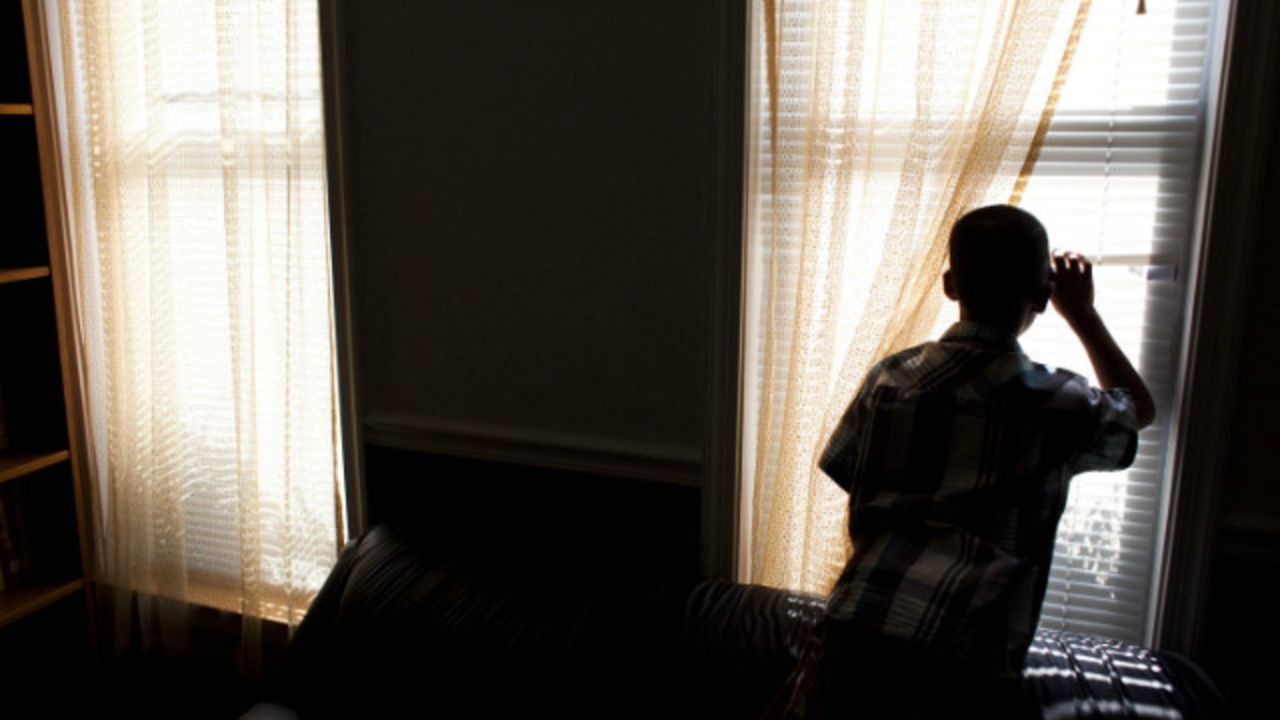 The boy looks out the window at his temporary home in Baltimore.