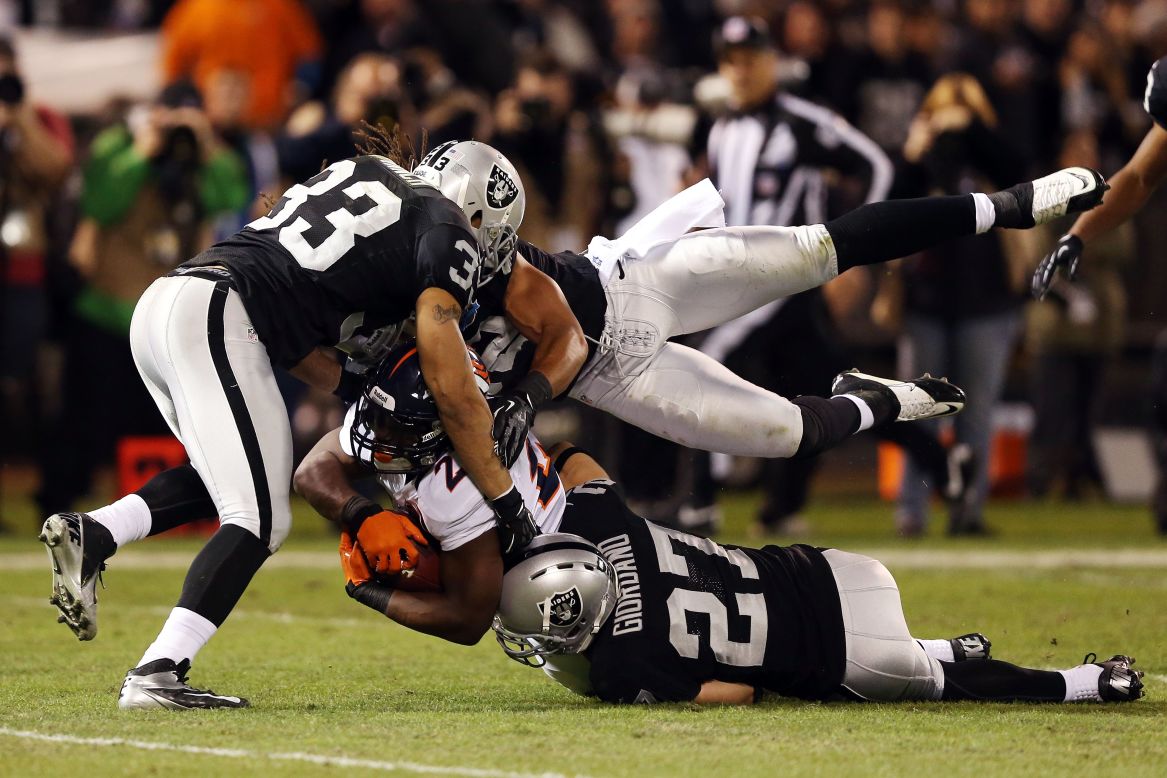Knowshon Moreno of the Denver Broncos gets tackled by three Oakland Raiders players during second quarter on Thursday.