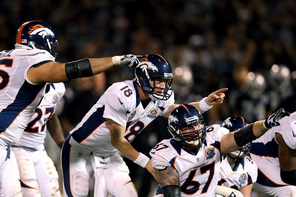 Quarterback Peyton Manning of the Denver Broncos calls out a play change behind center Dan Koppen during their game against the Oakland Raiders at Oakland-Alameda County Coliseum on Thursday, December 6, in Oakland, California. 