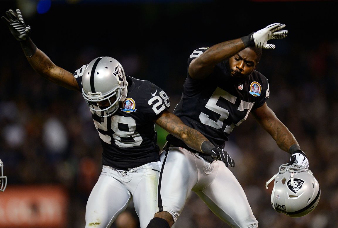 Phillips Adams, left, and Keenan Clayton of the Oakland Raiders celebrate after Adams intercepted a pass against the Denver Broncos in the second quarter on Thursday.