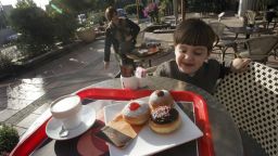 A young Israeli boy looks at a serving of fresh oil-fried and jam-filled doughnuts, known in Hebrew as "sufganiyot", served at one of the local bakeries in Kadima, central Israel, during Hanukkah.