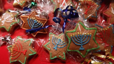 Gingerbread cookies in the shape of Stars of David and decorated with a Hanukkiah candelabrum.