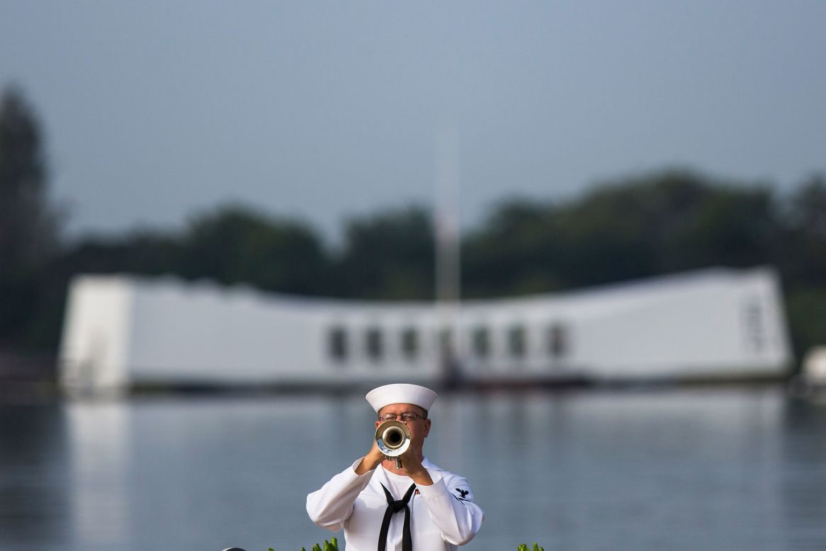 A U.S. Navy musician plays "Taps" in front of the USS Arizona Memorial during the 71st Annual Memorial Ceremony commemorating the WWII attack on Pearl Harbor at the World War II Valor in the Pacific National Monument on Friday, December 7, in Pearl Harbor, Hawaii.