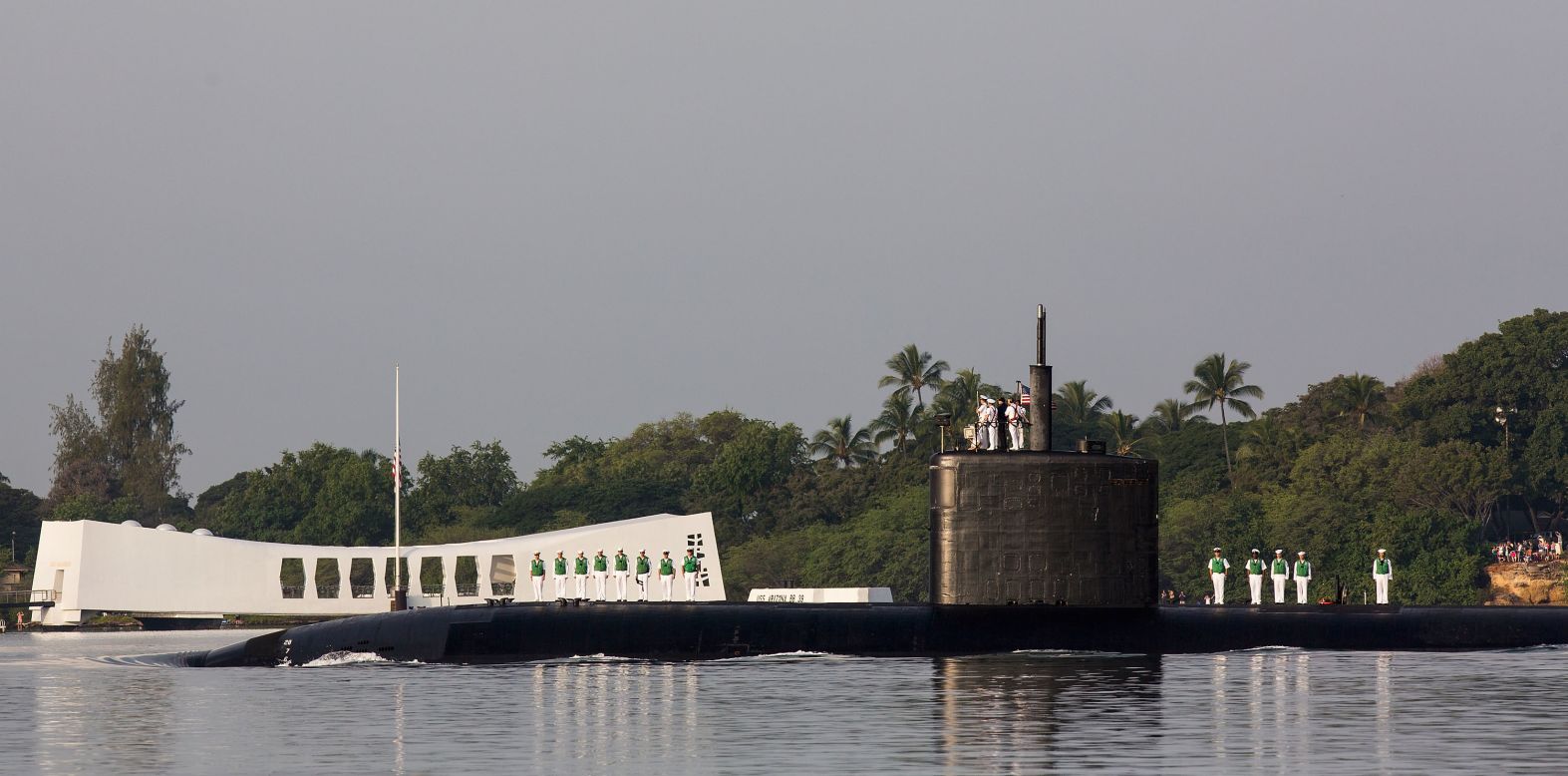 The USS Tucson performs a pass in review near the USS Arizona Memorial in Pearl Harbor, Hawaii.