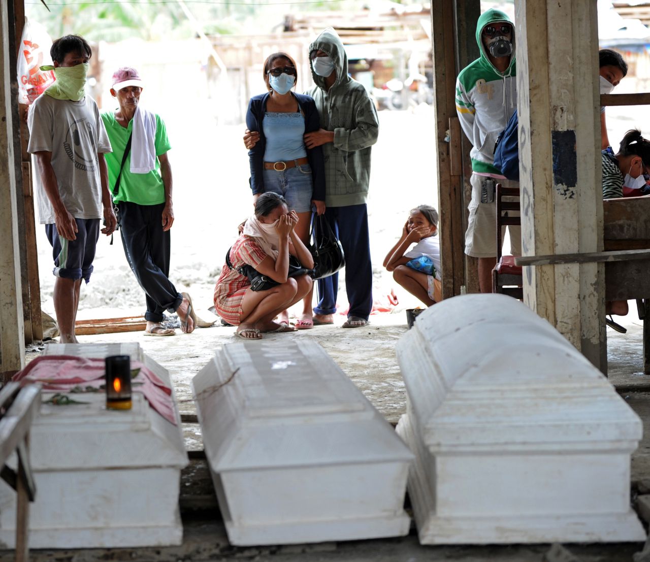 Residents in New Bataan mourn near coffins of relatives who died during flash floods caused by Typhoon Bopha on Saturday, December 8.