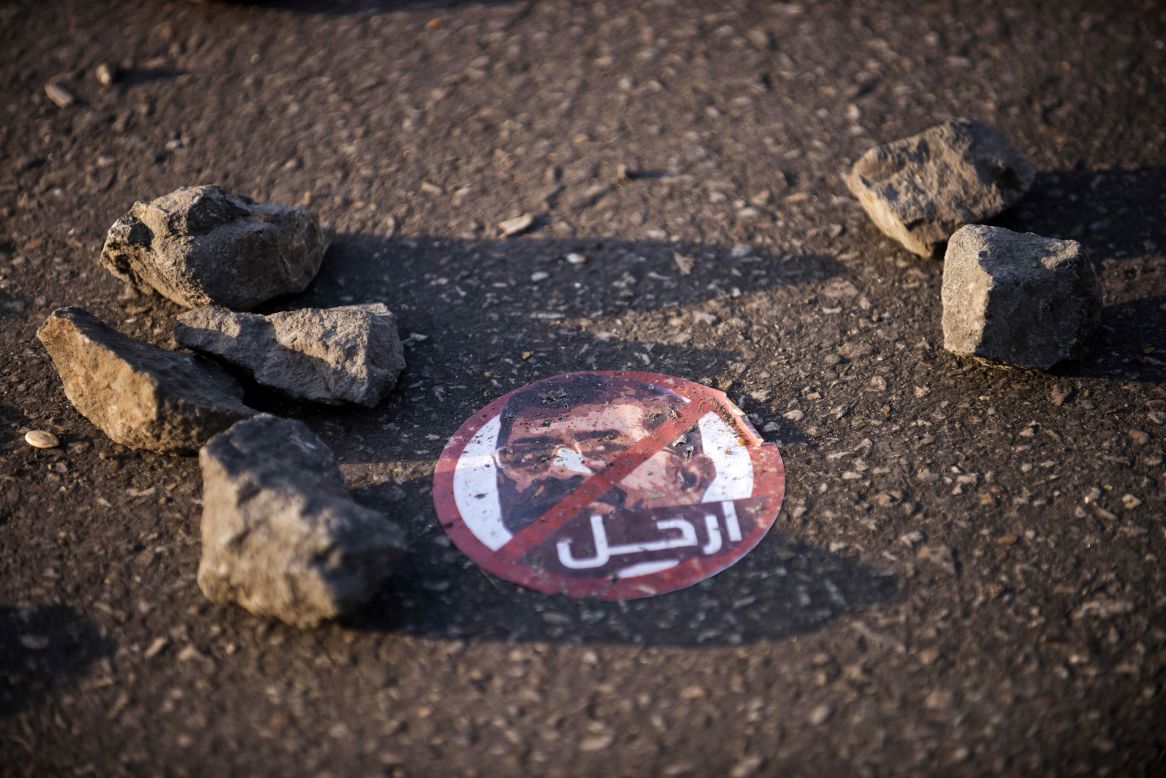 A sticker depicting Egyptian President Mohamed Morsy reads "leave" on the ground near the presidential palace on December 8.
