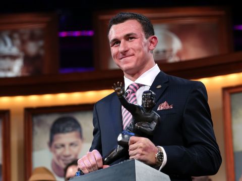 Quarterback Johnny Manziel of the Texas A&M University Aggies poses with the Heisman Memorial Trophy after being named the 78th Heisman Memorial Trophy Award winner at the Best Buy Theater on December 8 in New York City.