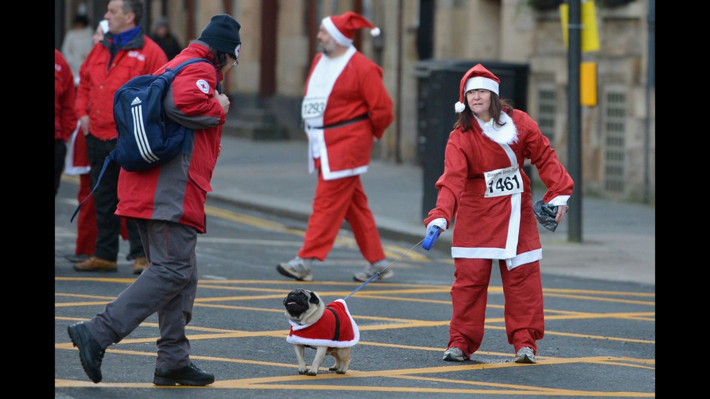 A woman and her dog in Santa suits prepare for the annual Glasgow Santa Dash on December 9 in Glasgow, Scotland.