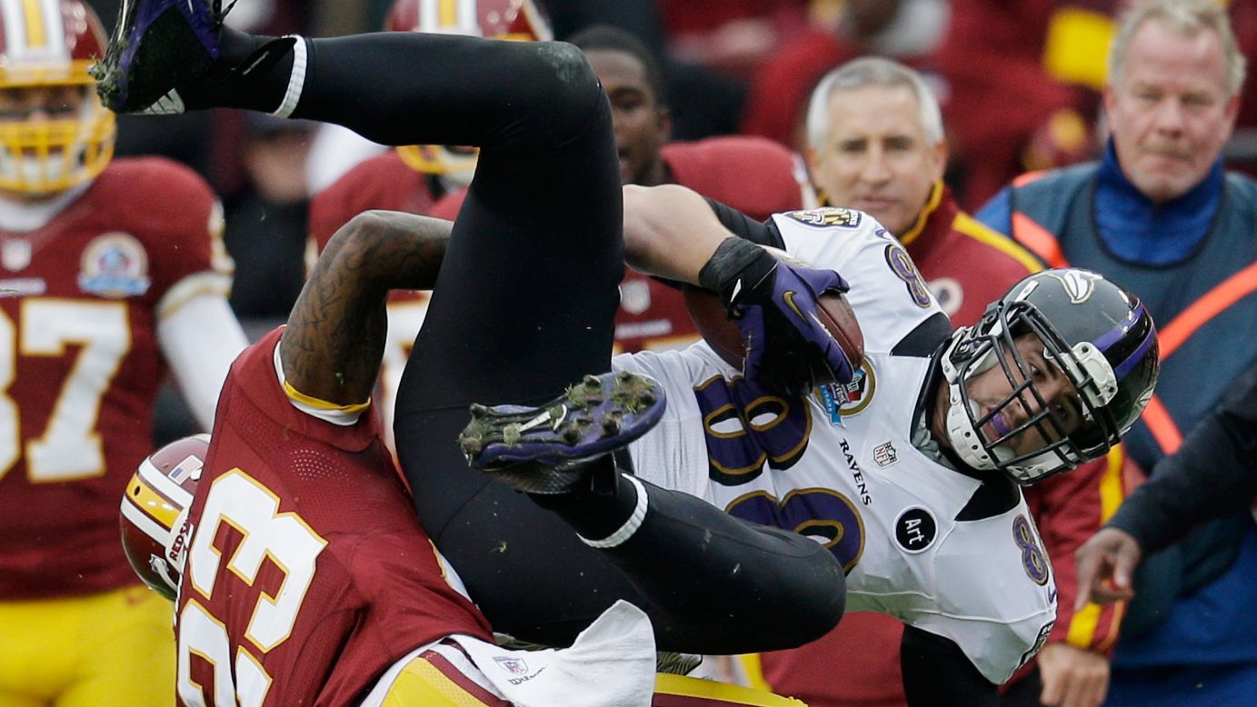 Ravens tight end Dennis Pitta is tackled by Redskins cornerback DeAngelo Hall after catching a first-half pass on Sunday.