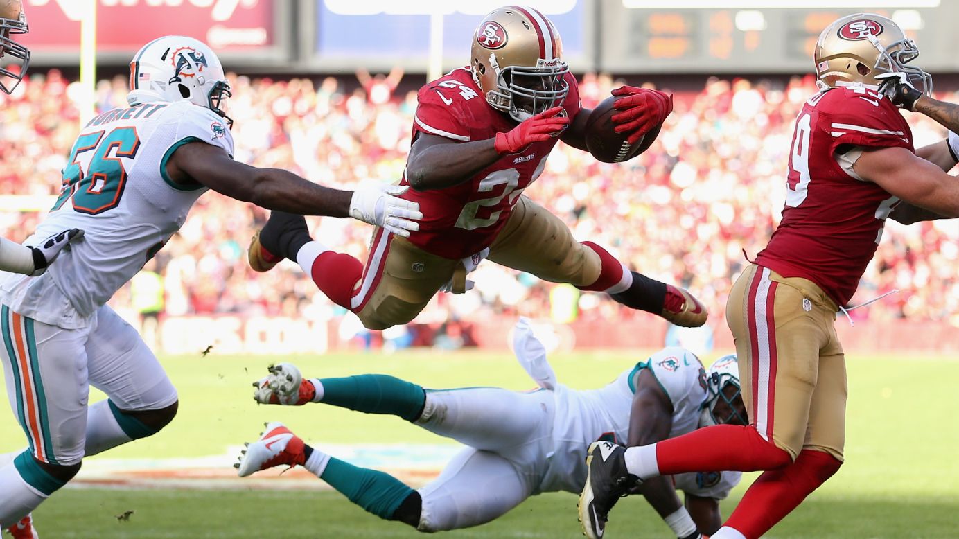 San Francisco 49ers running back Anthony Dixon leaps over safety Chris Clemons of the Miami Dolphins at Candlestick Park on Sunday in San Francisco, California.