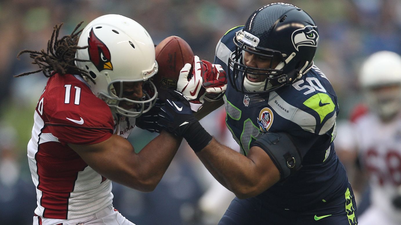 Seattle Seahawks linebacker K.J. Wright  tries to wrestle the ball away from Arizona Cardinals wide receiver Larry Fitzgerald during the first quarter on Sunday.