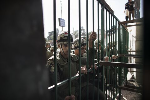 Egyptian army troops stand guard in front of a metal barricade on December 11.