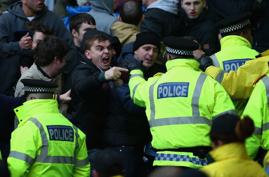 A total of 13 fans were arrested and nine charged -- one with making alleged racist chants. Here a City supporter shouts across the police security cordon.