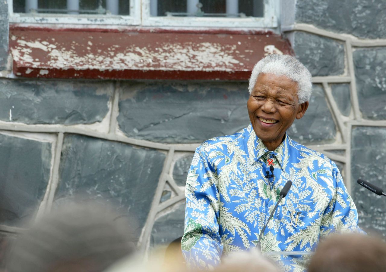 Mandela sits outside his former prison cell on Robben Island on November 28, 2003, ahead of his AIDS benefit concert at Green Point Stadium in Cape Town. He was sent to the infamous prison five miles off the coast of South Africa, where he spent 18 of his 27 years behind bars.