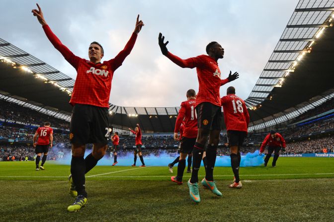 United's players celebrate Robin Van Persie's decisive late goal in a 3-2 victory -- which was met by missiles and smoke bombs hurled by City supporters.