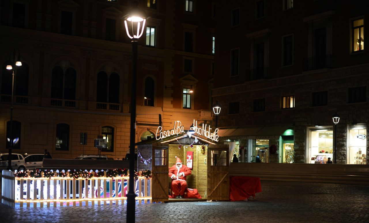 A man dressed as Santa waits for customers in a wooden house in Rome on December 11.