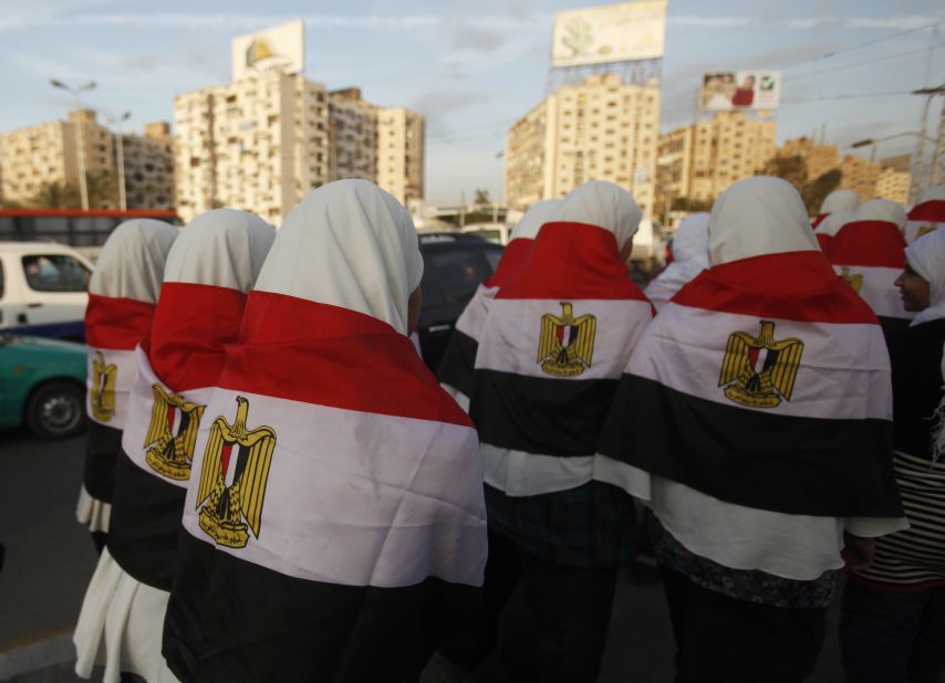 Girls walk with Egypt's national flag draped over their backs to a rally for supporters of President Mohamed Morsy in Cairo on Tuesday, December 11.