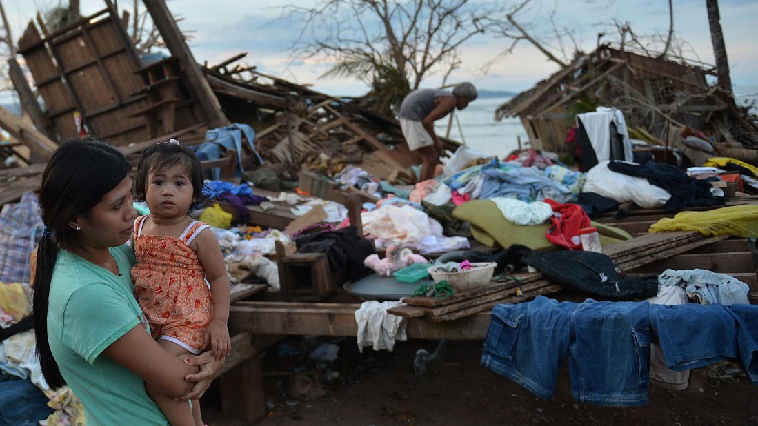 A woman stands next to her destroyed house in Boston, Davao Oriental province, on December 11.