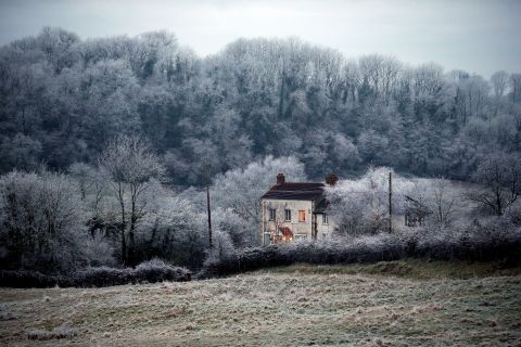 Frost lingers on trees surrounding a house near Wells on December 12 in Somerset, England.