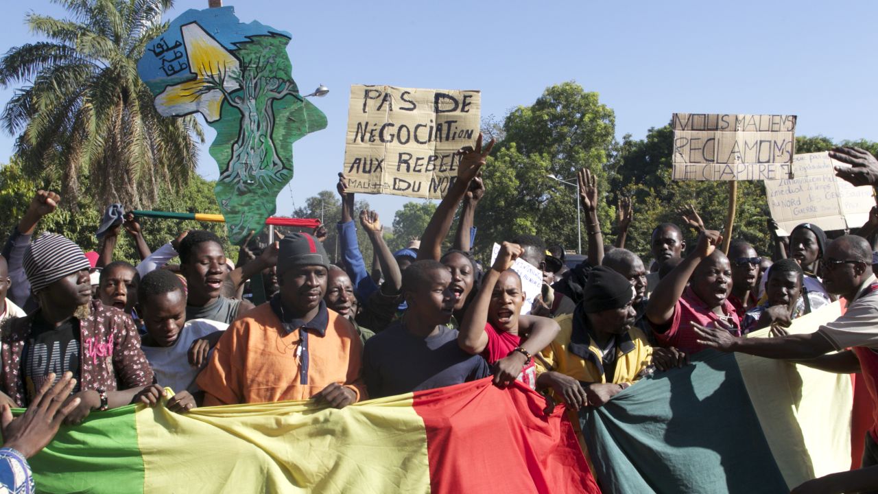 A man holding a banner that reads 'No negotiation with rebels' joins thousands of others in Bamako on December 8, 2012.