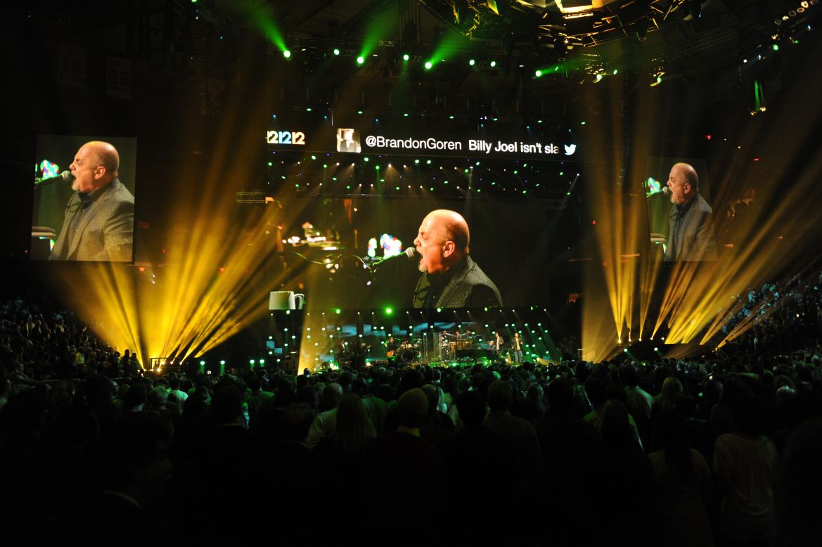 Jumbo screens project multiple images of Billy Joel's performance.