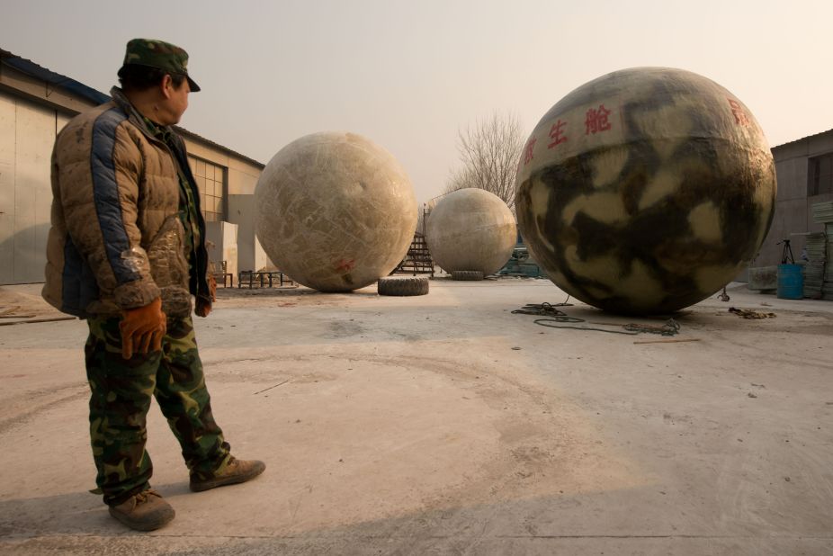 A worker looks at the pods. The spheres are airtight and can float on water.