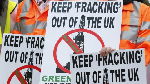 Demonstrators hold placards in protest against fracking outside Parliament in London on December 1, 2012.