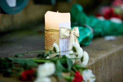 Flowers and candles sit outside the Clackamas Town Center mall in Clackamas, Oregon, on Thursday, December 13. The Clackamas County Sheriff's Office identified Jacob Tyler Roberts, 22, as the gunman who entered the mall with a AR-15 semiautomatic assault rifle, killing two and wounding another before taking his own life. 