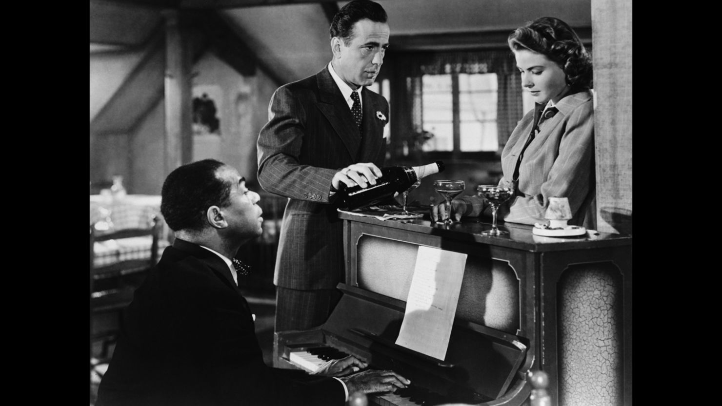 Humphrey Bogart and Ingrid Bergman listen as Dooley Wilson plays the small piano in the classic "Casablanca."