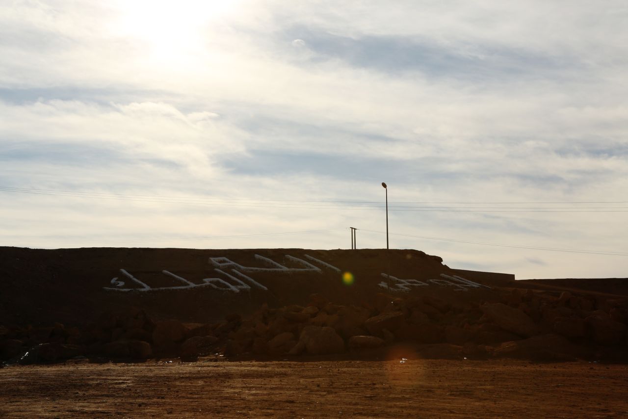 Letters on a hillside near an entrance to the city of Laayoune read "God, country, king."