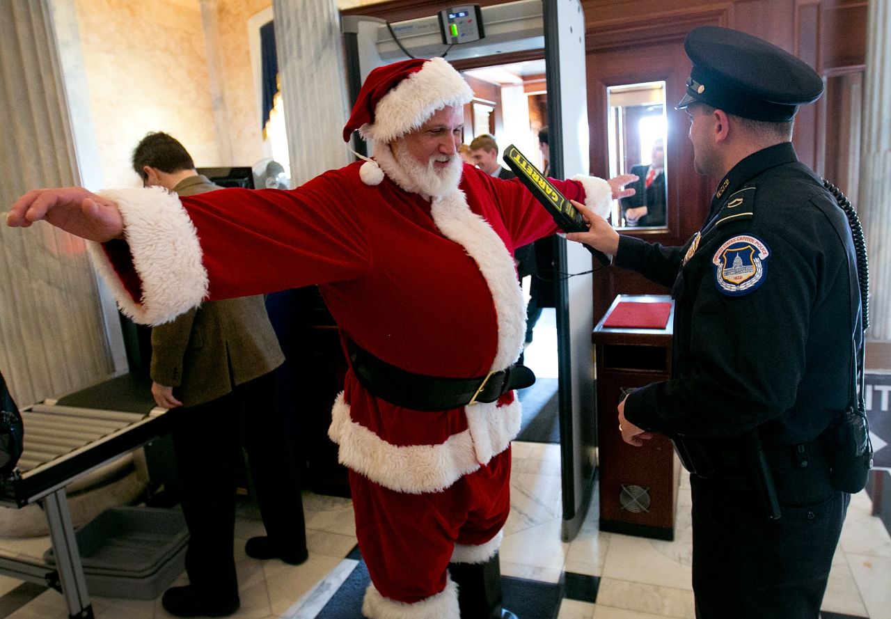 Police check a man dressed as Santa Claus as he passes through a metal detector at the U.S. Capitol on Wednesday, December 12, in Washington.
