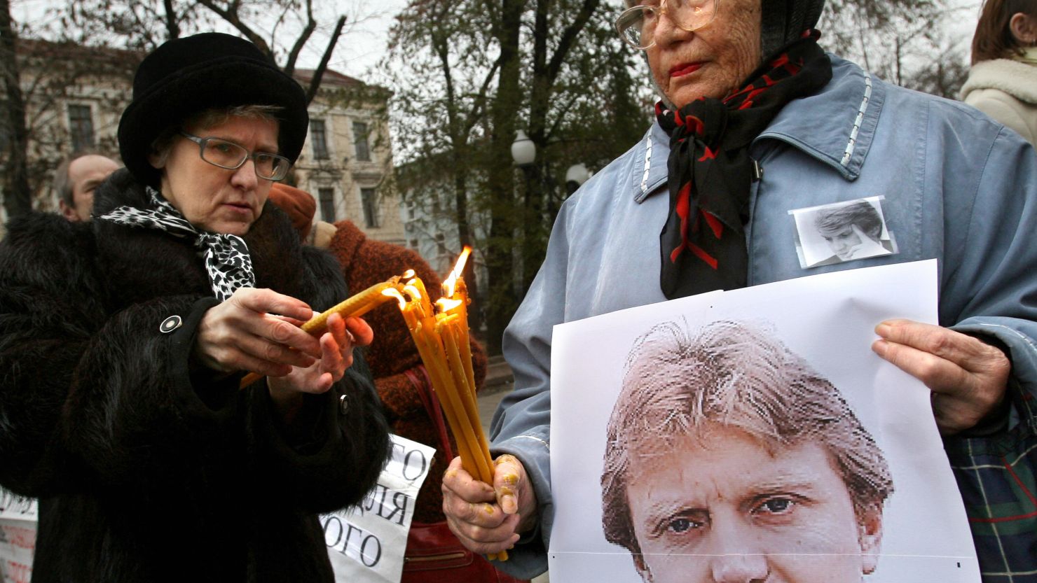 (File photo) Women holding a poster of Alexander Litvinenko light candles in his honor in Moscow on November 22, 2008. 