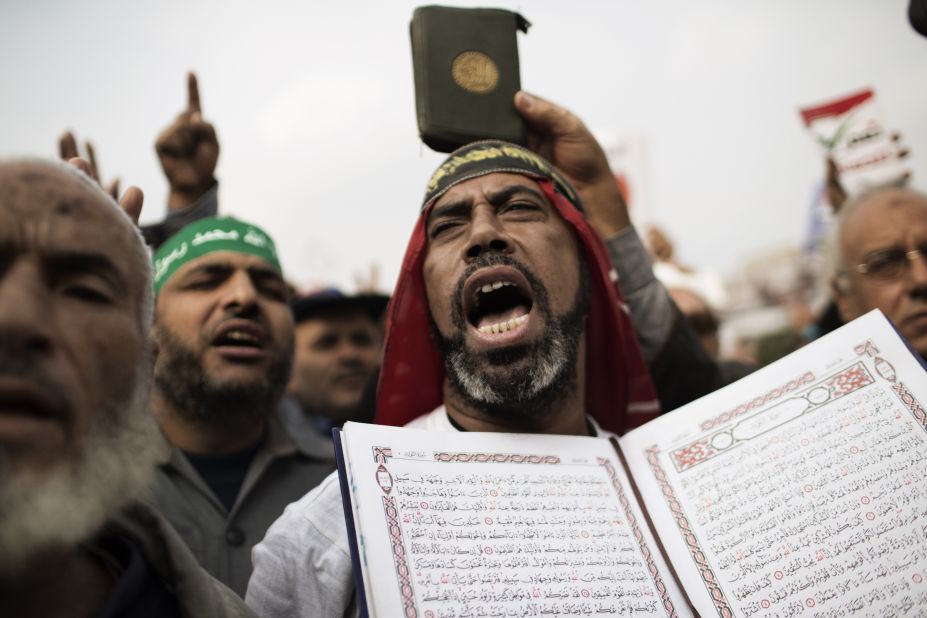A supporter of Egypt's President Mohamed Morsy and the Muslim Brotherhood holds Quran as he shouts during a demonstration in Cairo on Friday, December 14.