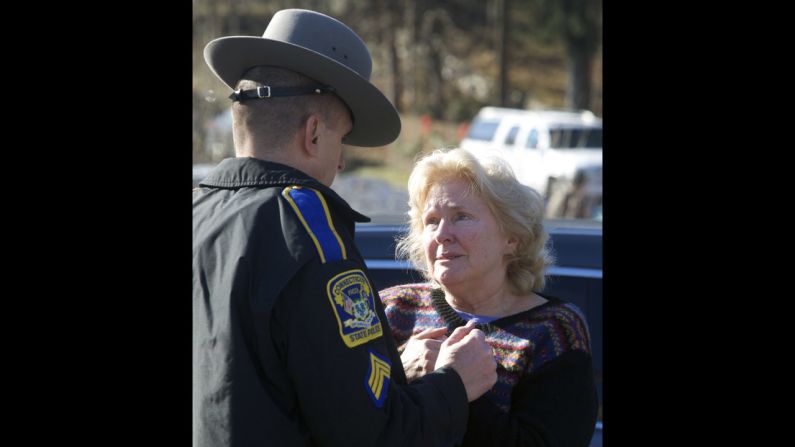 A woman speaks with a Connecticut state trooper outside Sandy Hook Elementary School on December 14.