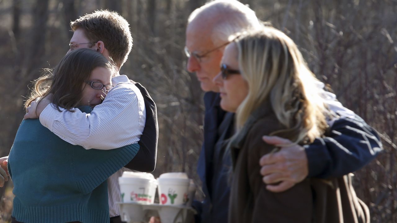 Family members embrace each other outside Sandy Hook Elementary School after Friday's shootings.