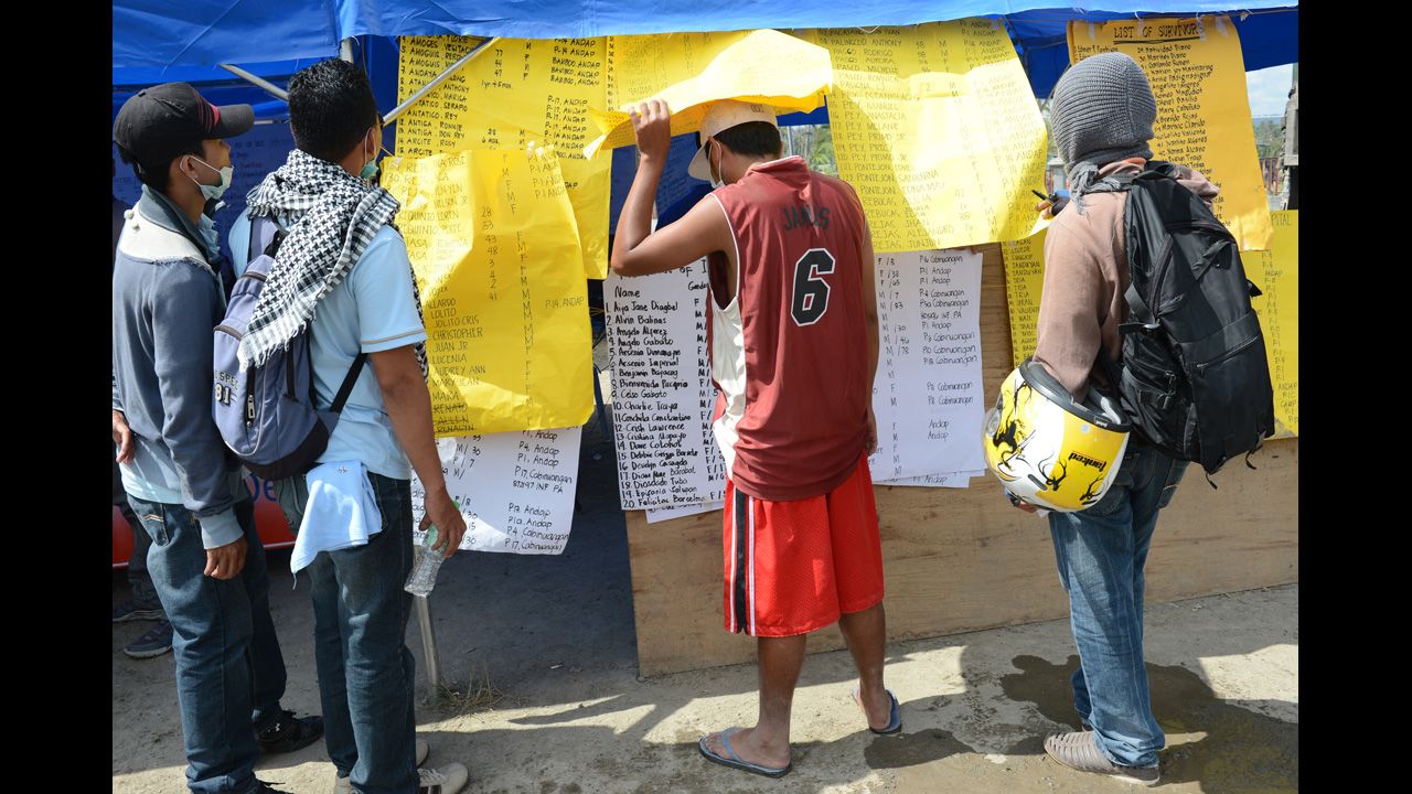 Residents look at the lists of missing relatives displayed near the municipal hall in New Bataan, Compostela province on Wednesday, December 12, nearly one week after the southern part of the Philippines was hit by Typhoon Bopha. Bopha, the strongest cyclone to hit the Philippines in decades, has taken more than 700 lives and hundreds remain missing, the government said on December 11. The United Nations launched a $65 million global appeal on December 10 to help survivors.